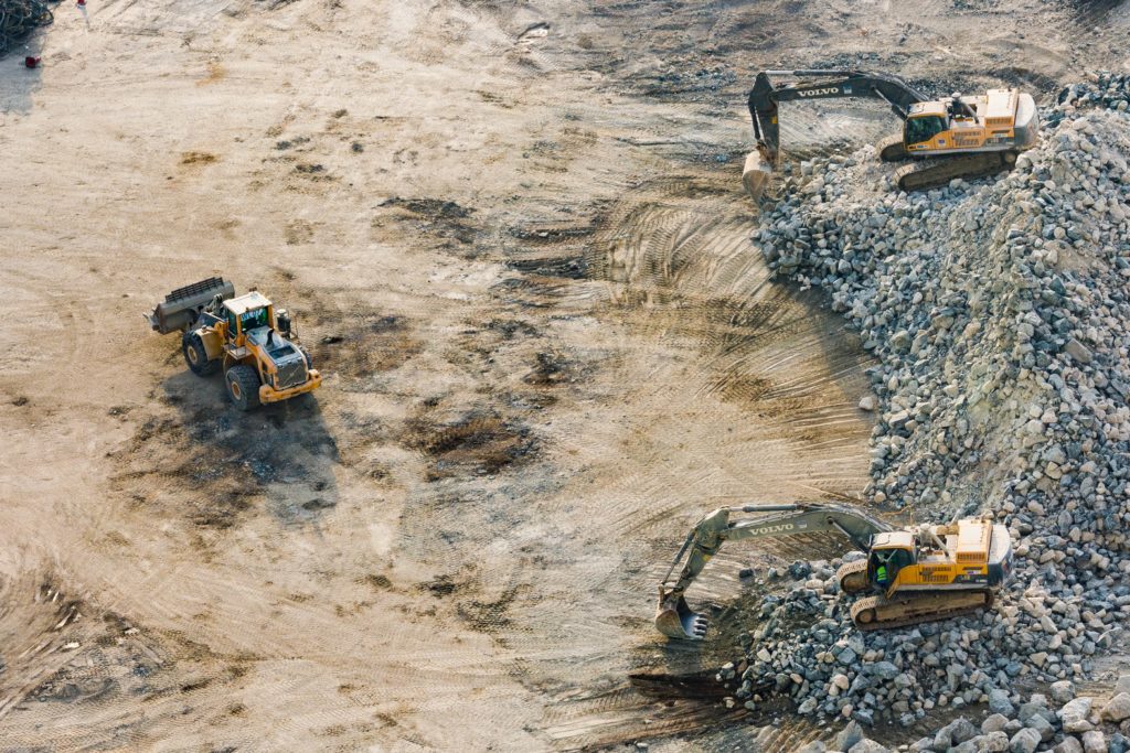 Des excavateurs en train de déblayer un terrain.